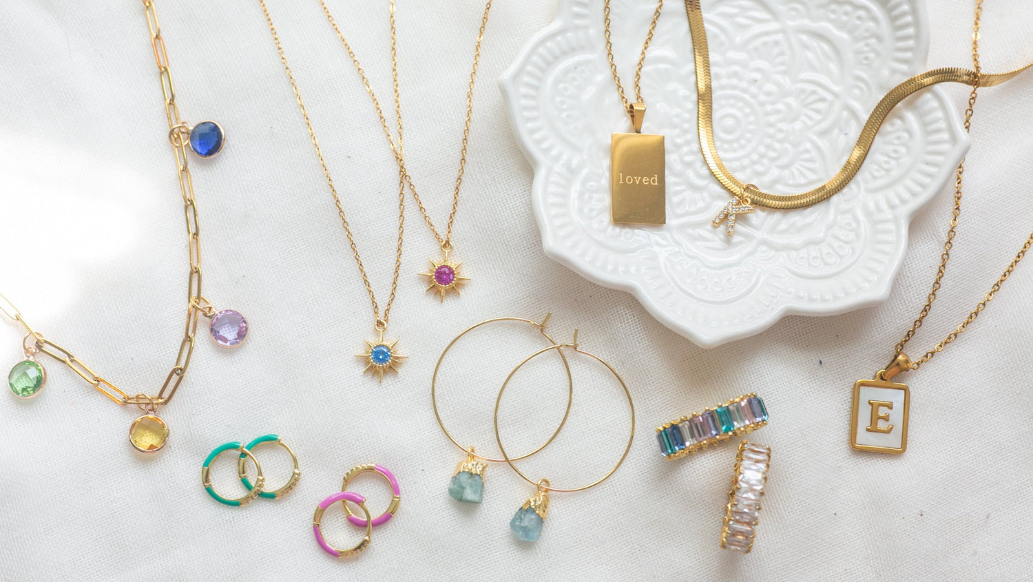 Stylish jewelry with meaning, initials and birthstone jewelry on white background